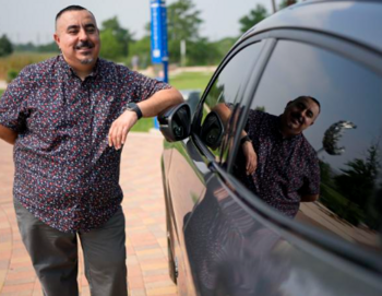 Man leaning against electric vehicle